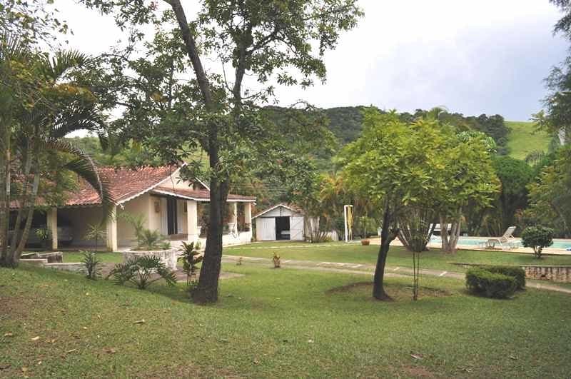 Comprar uma chácara: imagem mostra uma casa em meio a árvores e gramado.