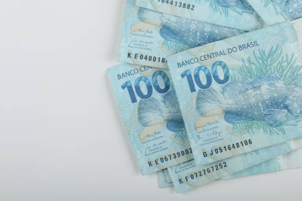 Consórcio ou poupança: notas de cem reais estão colocadas em uma superfície