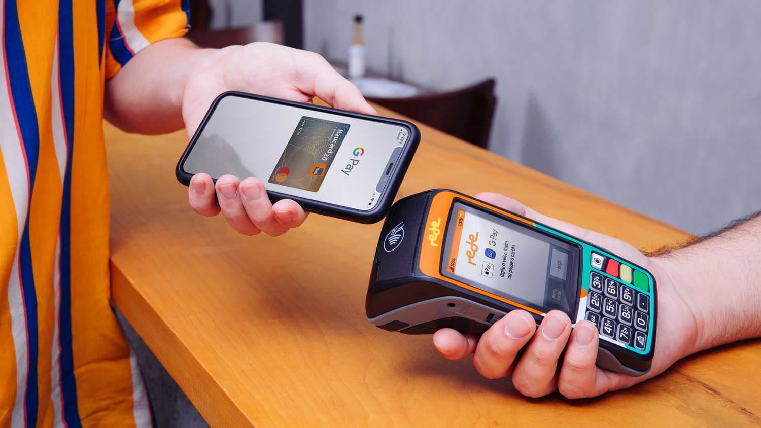Uma pessoa utiliza o Google Pay e efetua um pagamento por aproximação com o celular,