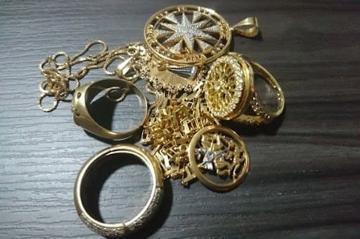 Penhor de joias: diversos bens estão espalhados em uma superfície escura.