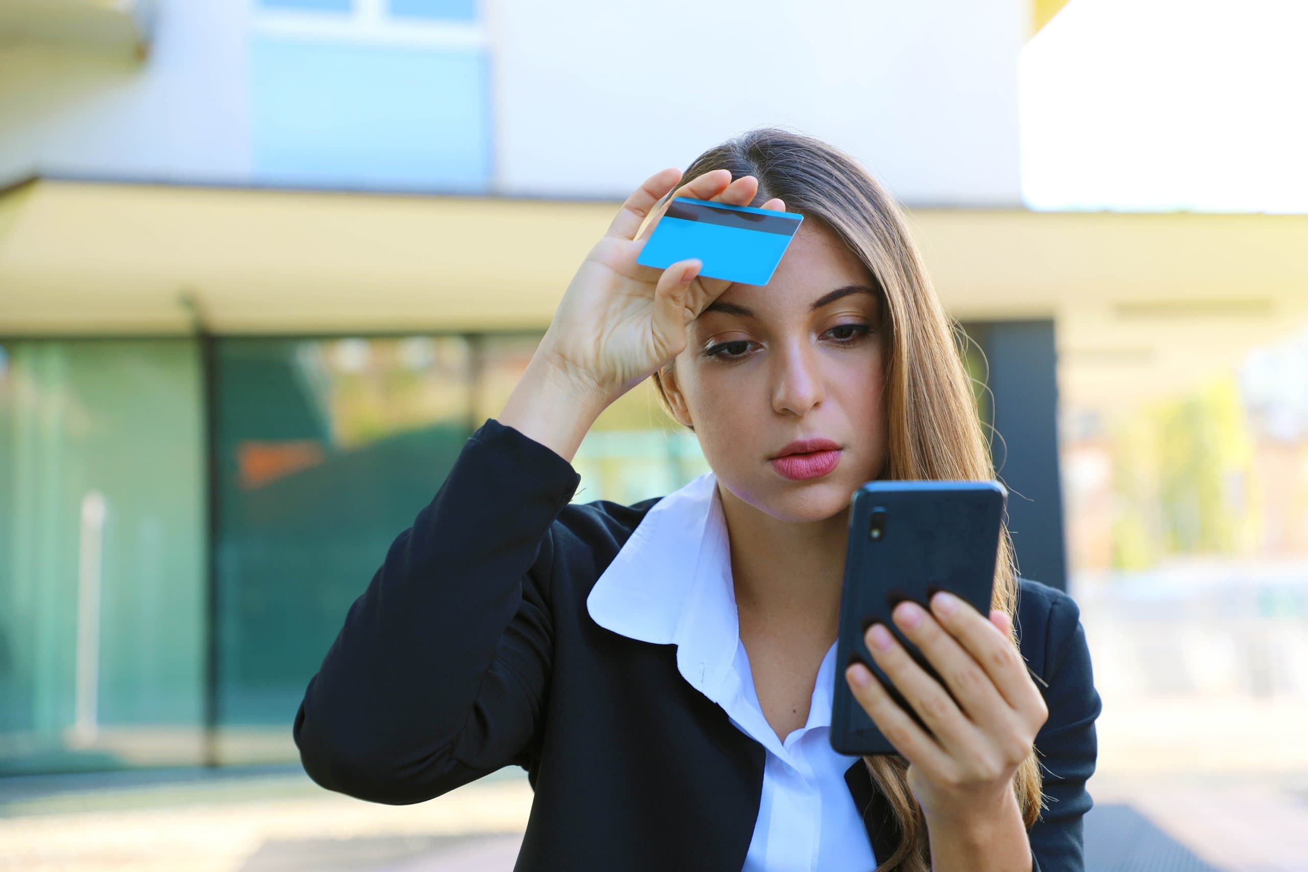 cartão: mulher segurando celular em uma mão e na outra um cartão, próximo a testa