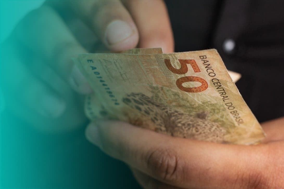 empréstimo: mãos masculinas contando notas de cinquenta reais