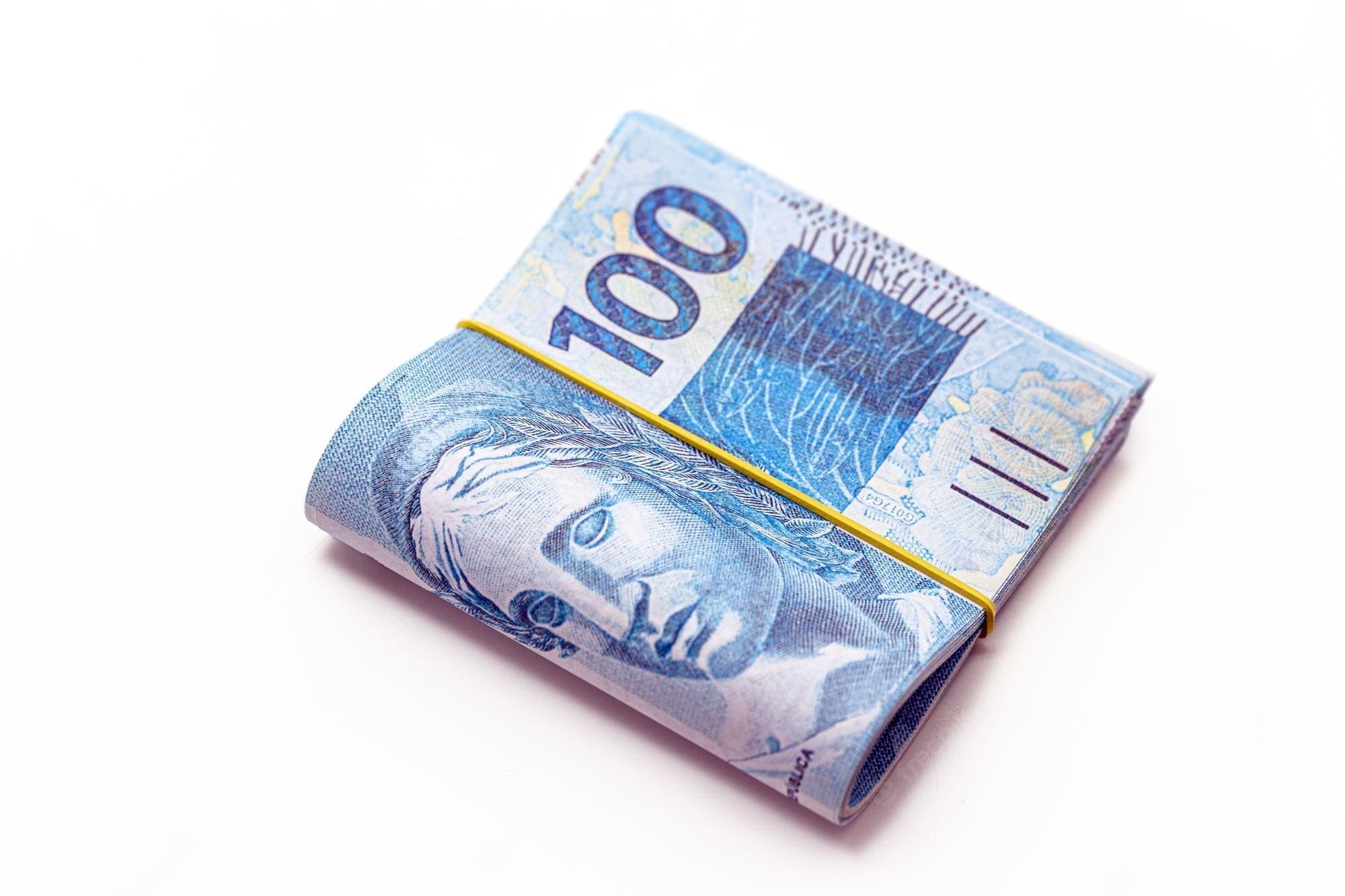Auxílio Brasil: notas de cem reais em um "bolo"