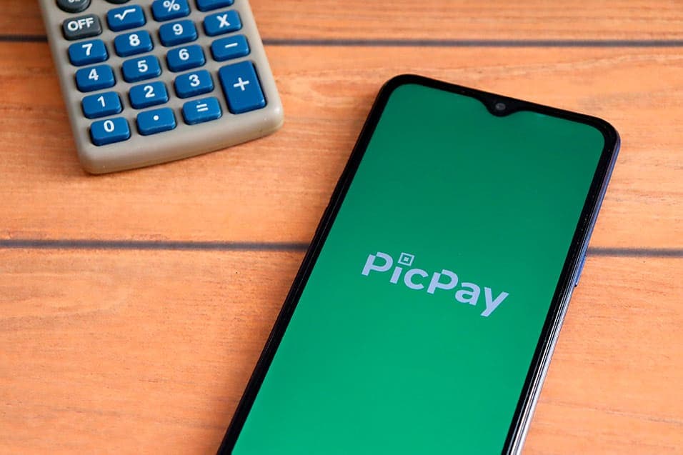 cartão de crédito: celular mostrando o logo do picpay e calculadora ao lado
