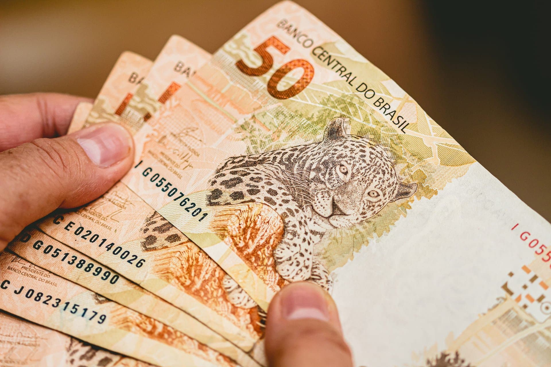 Auxílio Brasil: homem contando notas de cinquenta reais