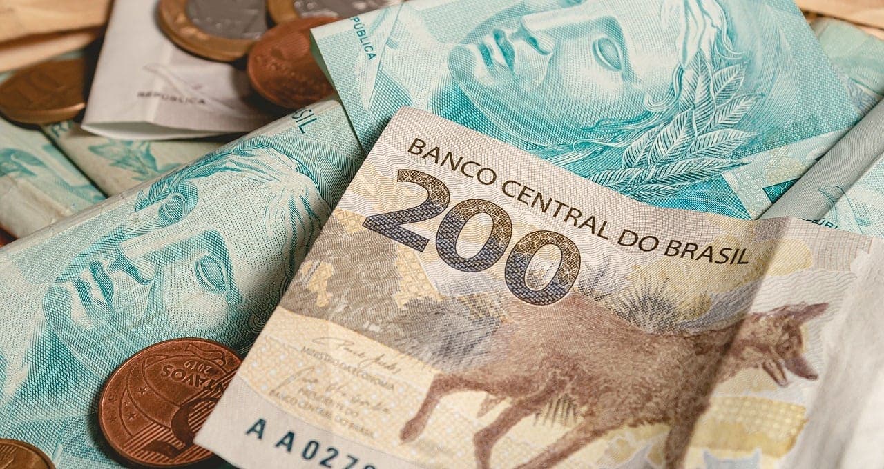 Dinheiro extra: imagem mostra notas de duzentos e cem reais, e algumas moedas.