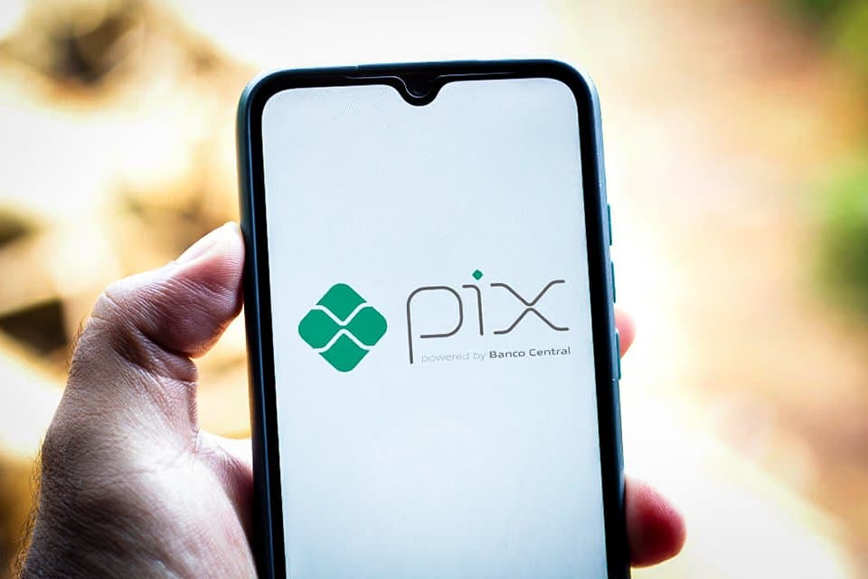 Bolepix: uma pessoa segura um celular e, na tela, é apresentado o logo Pix