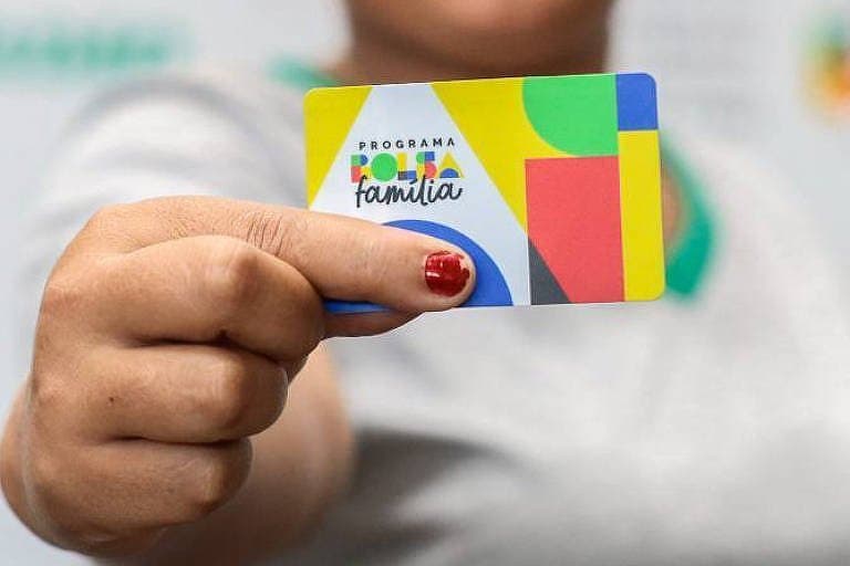 Empréstimo pelo Bolsa Família: mulher segura o carta do benefício de transferência de renda