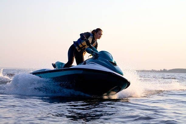 Como comprar jet ski: uma mulher está conduzindo um jet ski.