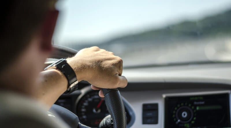 Seguro para Corolla: um homem segura o volante.