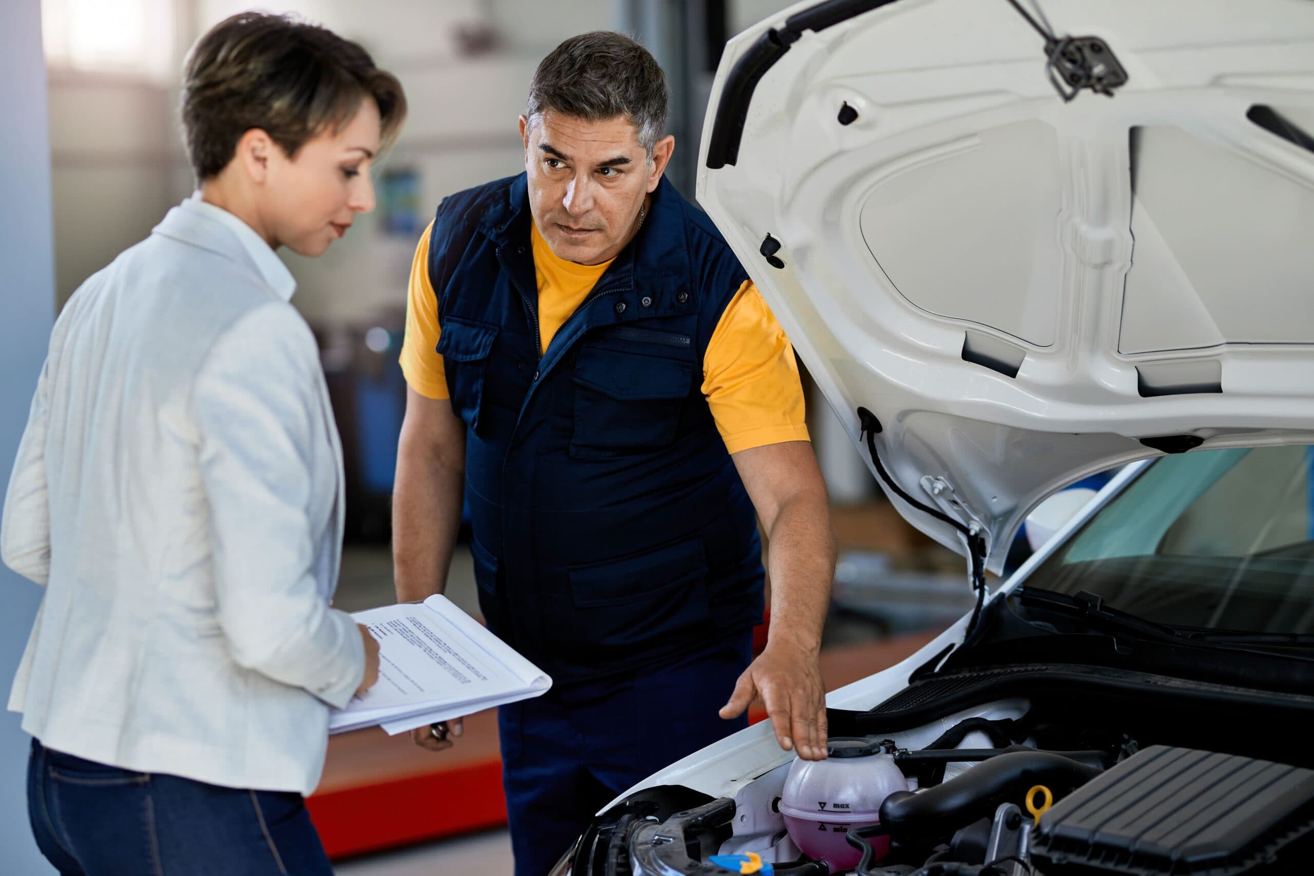 homem e mulher vistoriando um veículo (vistoria prévia de seguro automotivo)