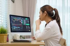 Uma mulher está usando o computador e buscando alternativas sobre como identificar ofertas de investimento fraudulentas
