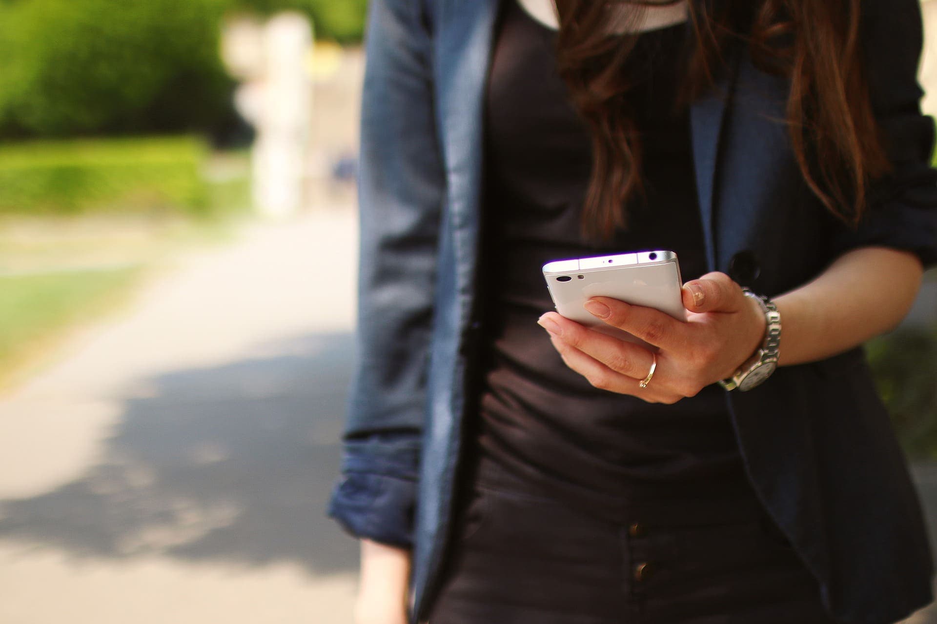 mulher segurando celular (estornar uma compra paga com PicPay)