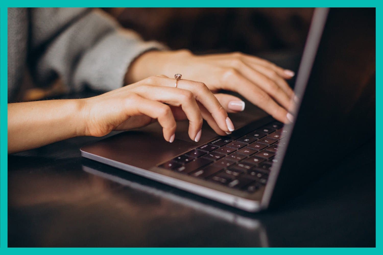 Empréstimo: uma mulher branca, com anel no dedo médio, está digitando em um notebook.