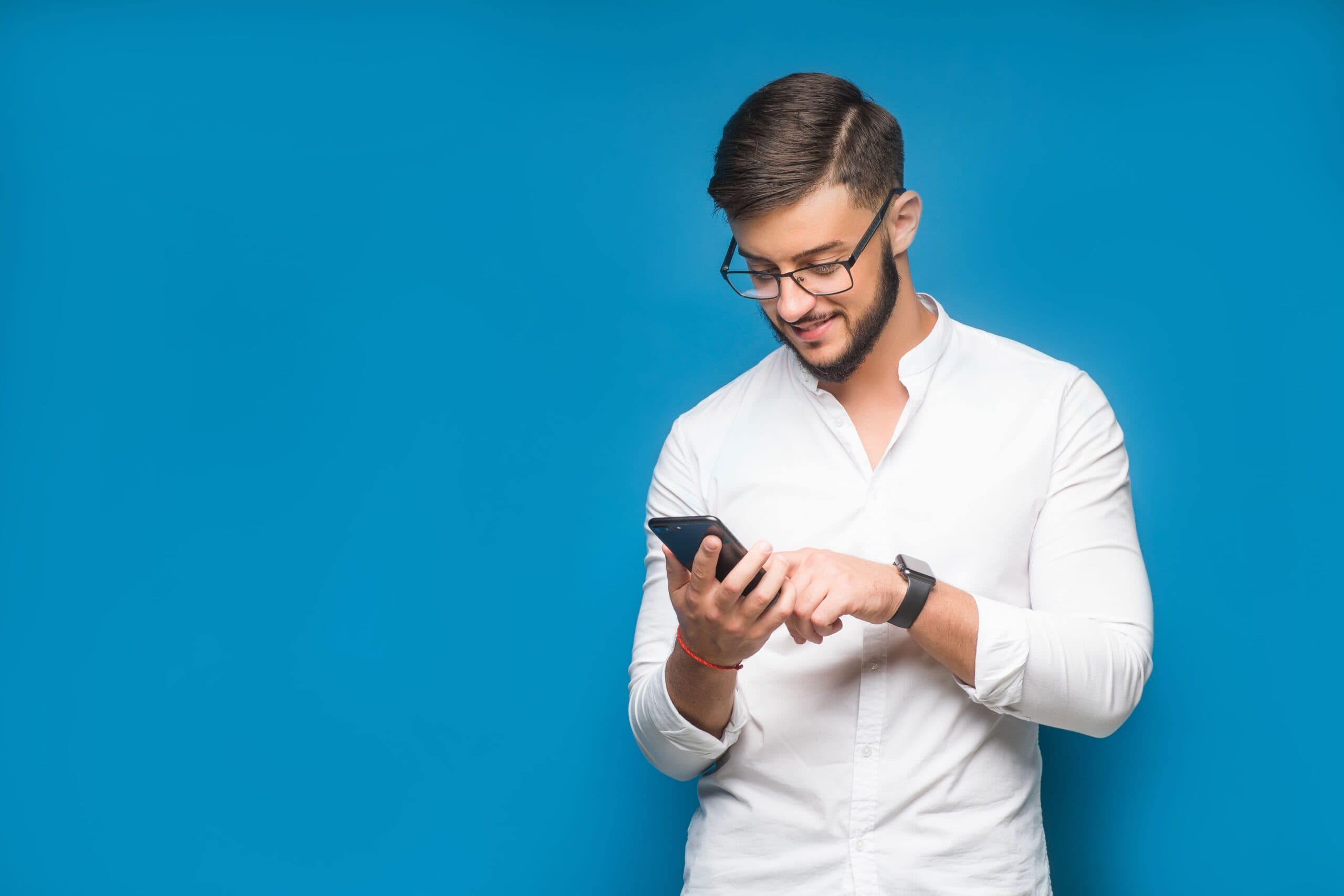 homem segurando celular e sorrindo (transferir dinheiro do Pagbank)