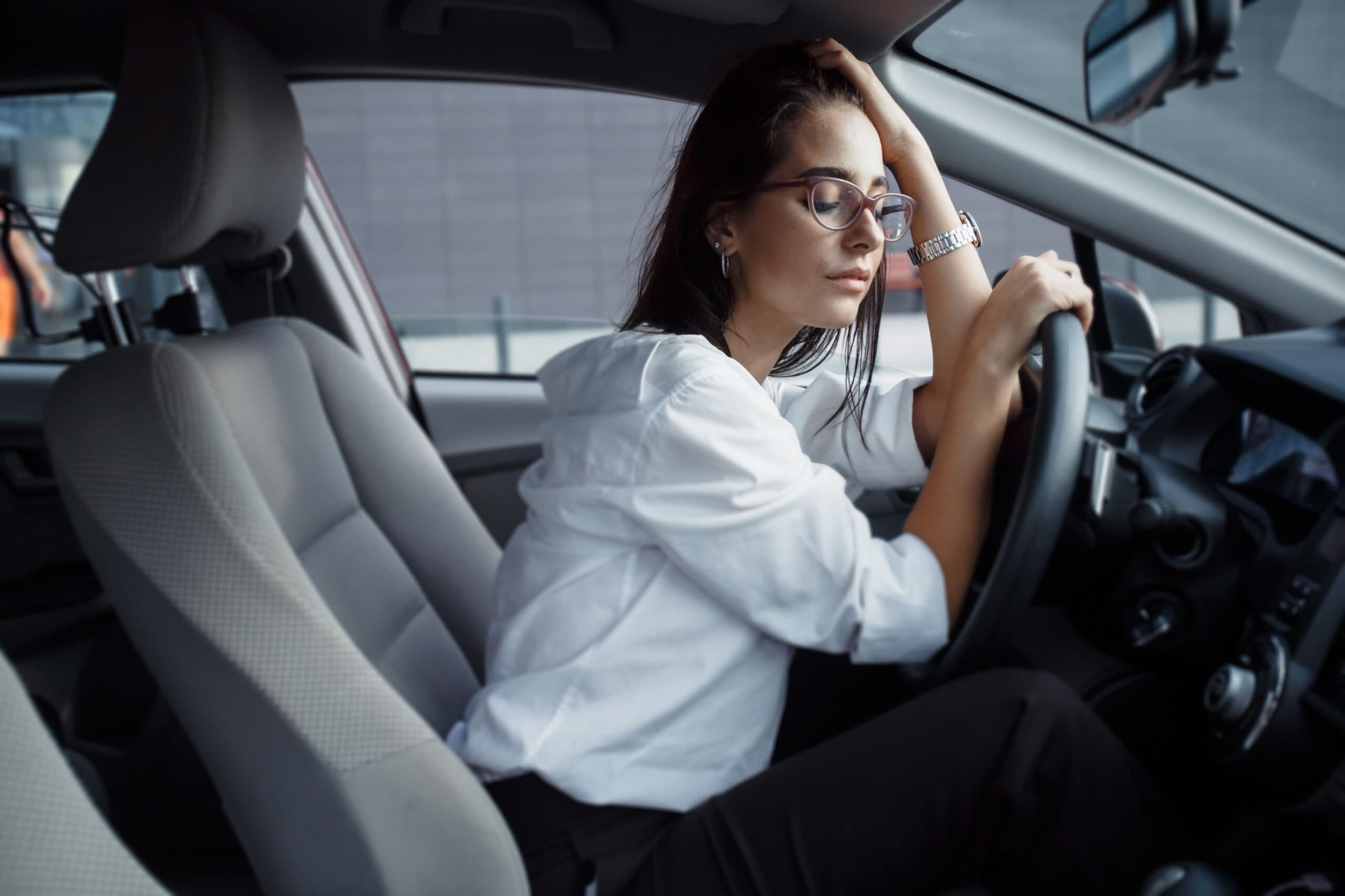 mulher no carro preocupada (pagar financiamento de veículo)