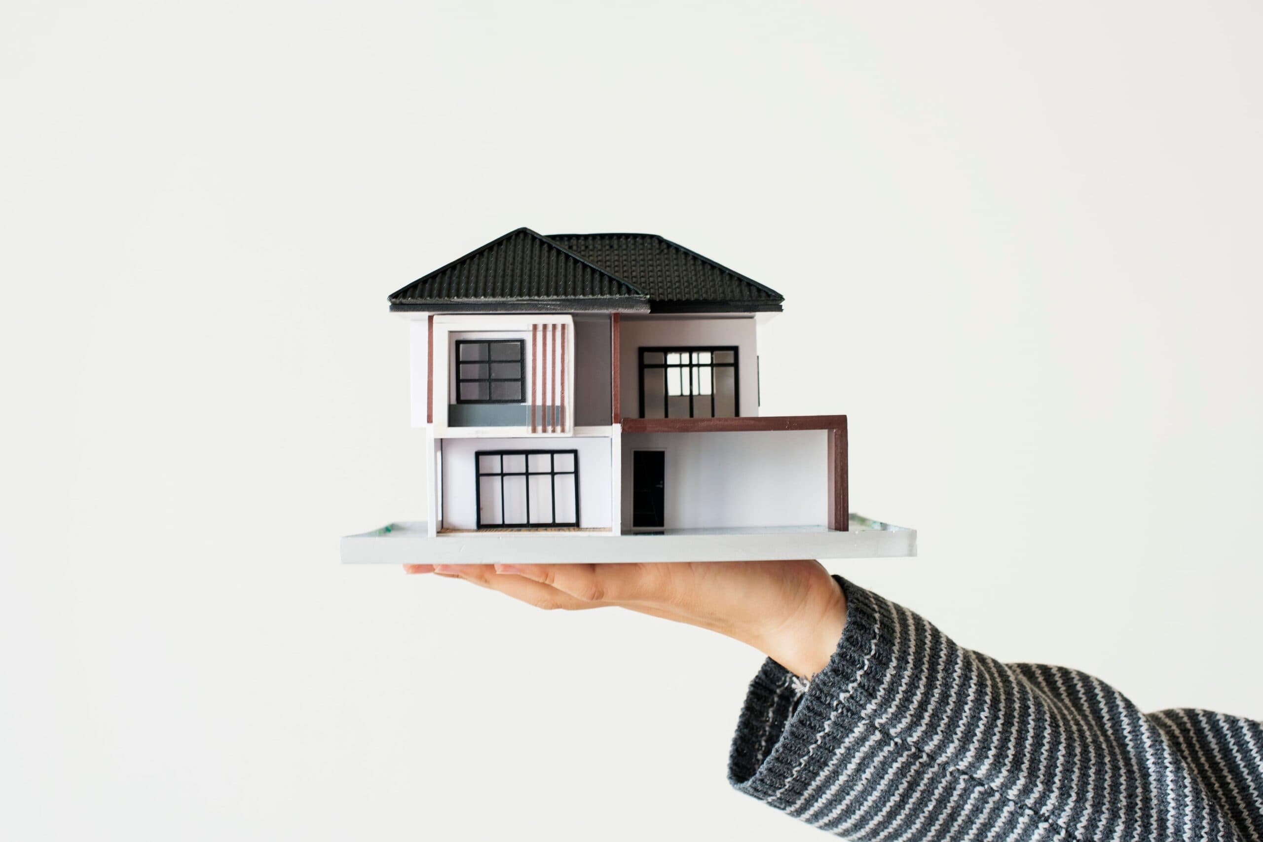 mulher segurando uma casa (não consigo financiar um imóvel)
