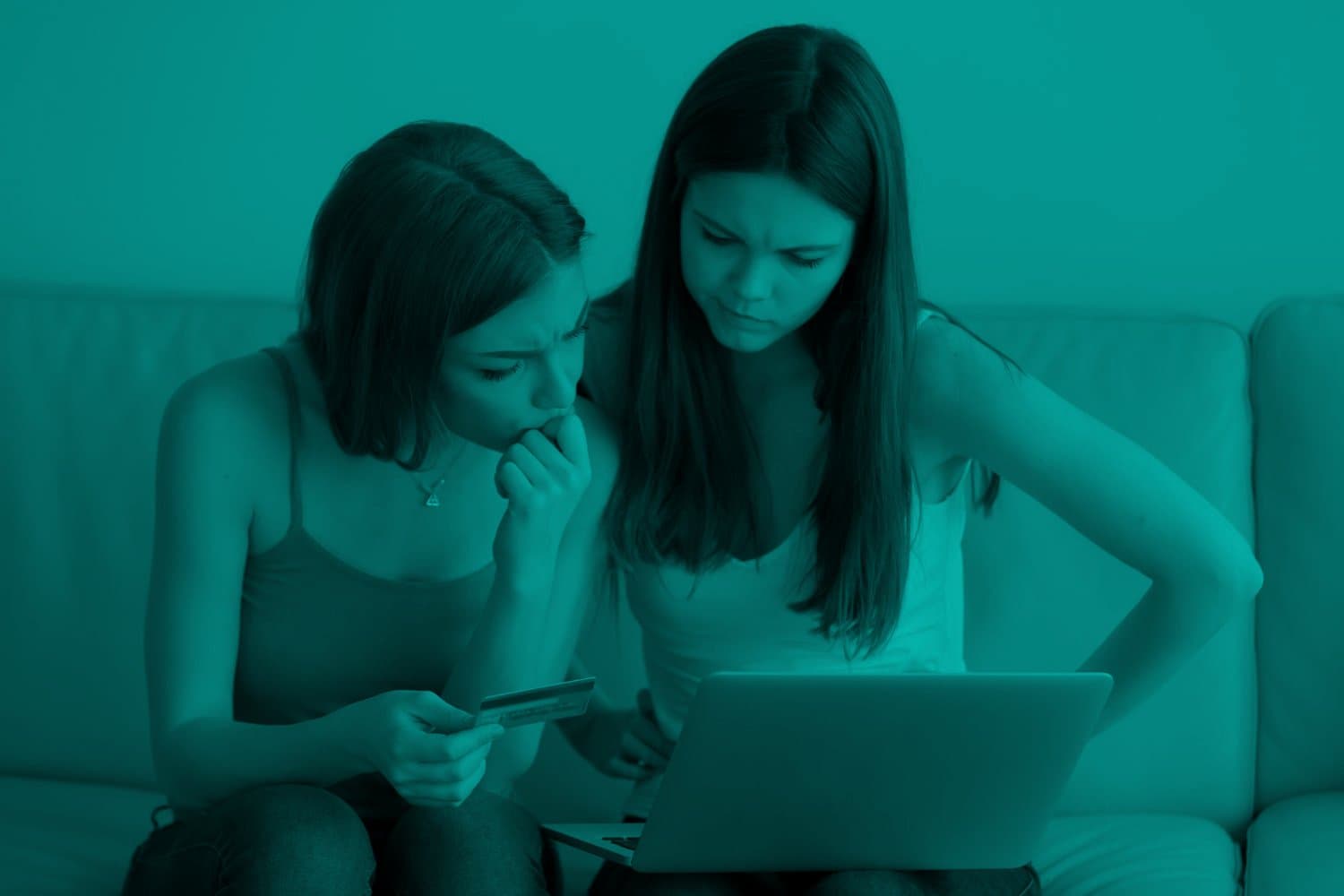 Cartão Cidadão: duas mulheres estão sentadas no sofá, em frente a um notebook. Elas possuem fisionomia de dúvida e uma delas segura um cartão na mão.