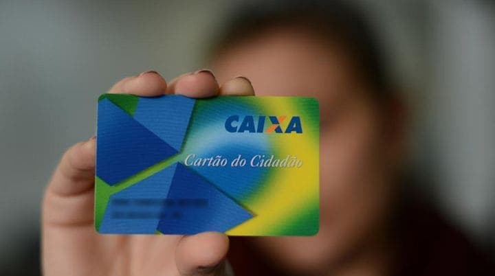 Uma mulher mostra o Cartão Cidadão.