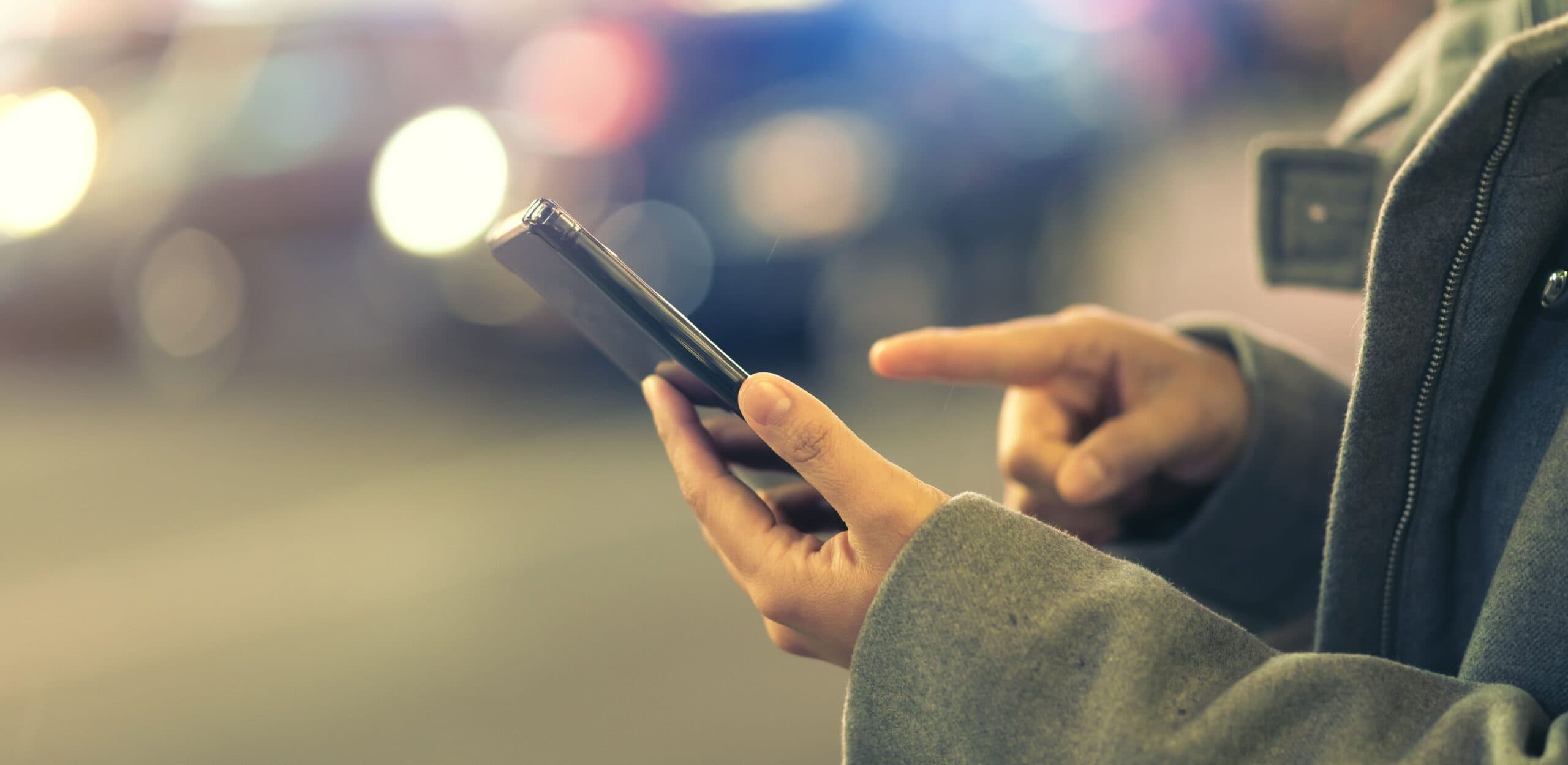 mulher segurando celular (consultar Auxílio Brasil pelo CPF)