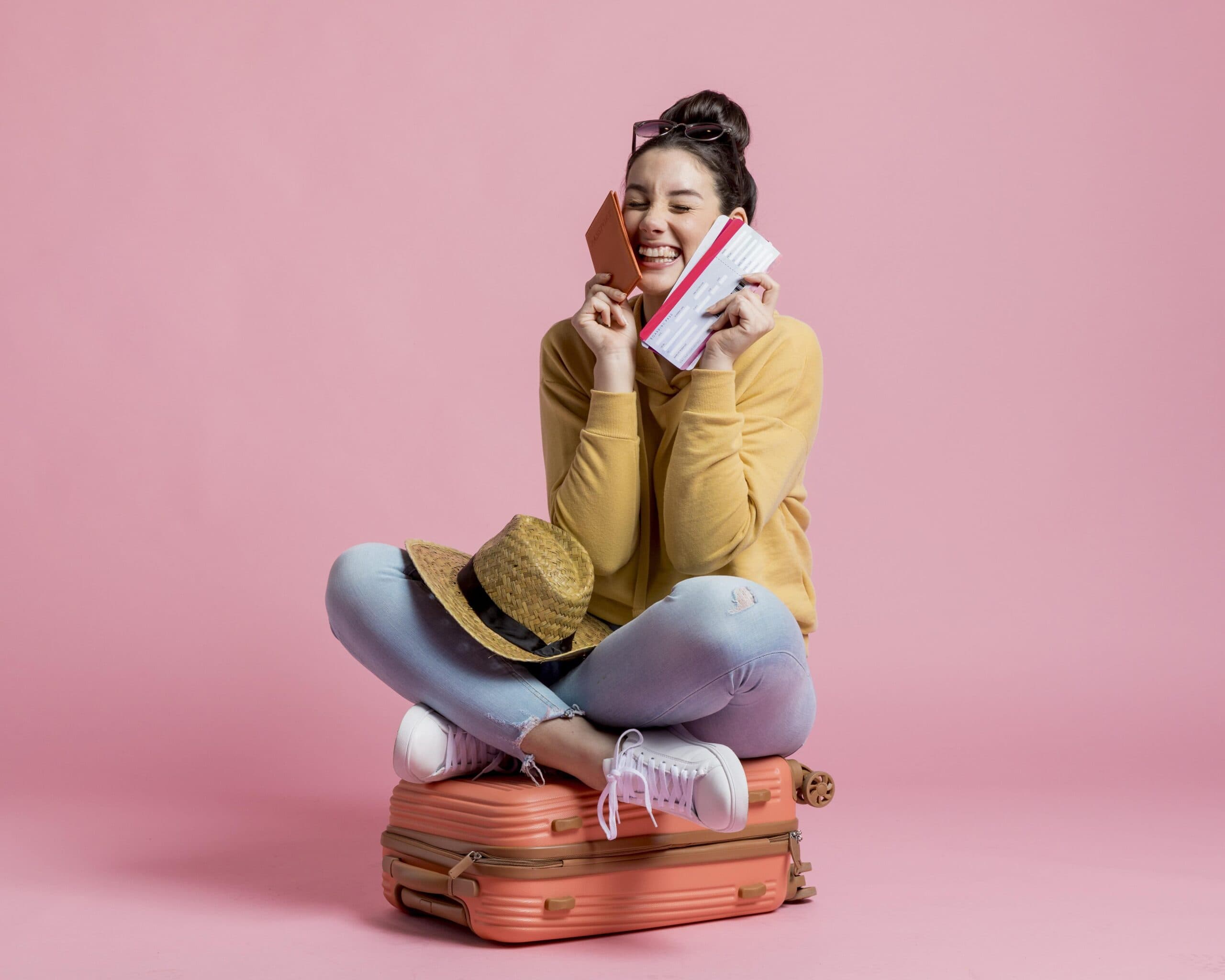 mulher sentada em mala e passagem na mão (empréstimo para viagem)