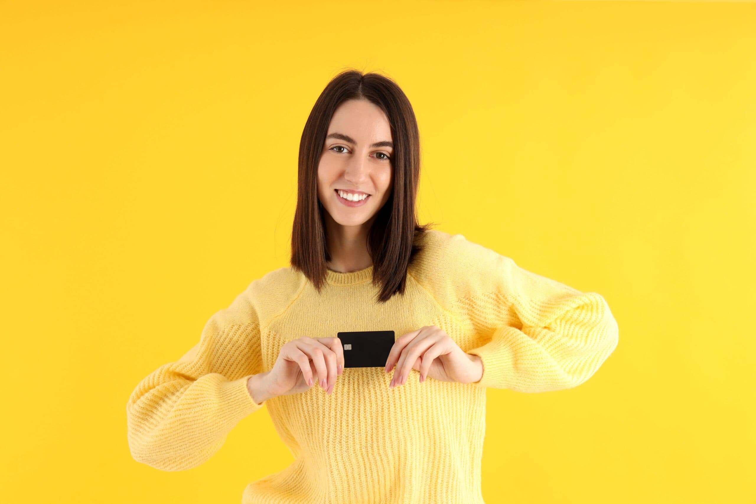 mulher feliz segurando cartão (cartão de crédito Girabank)