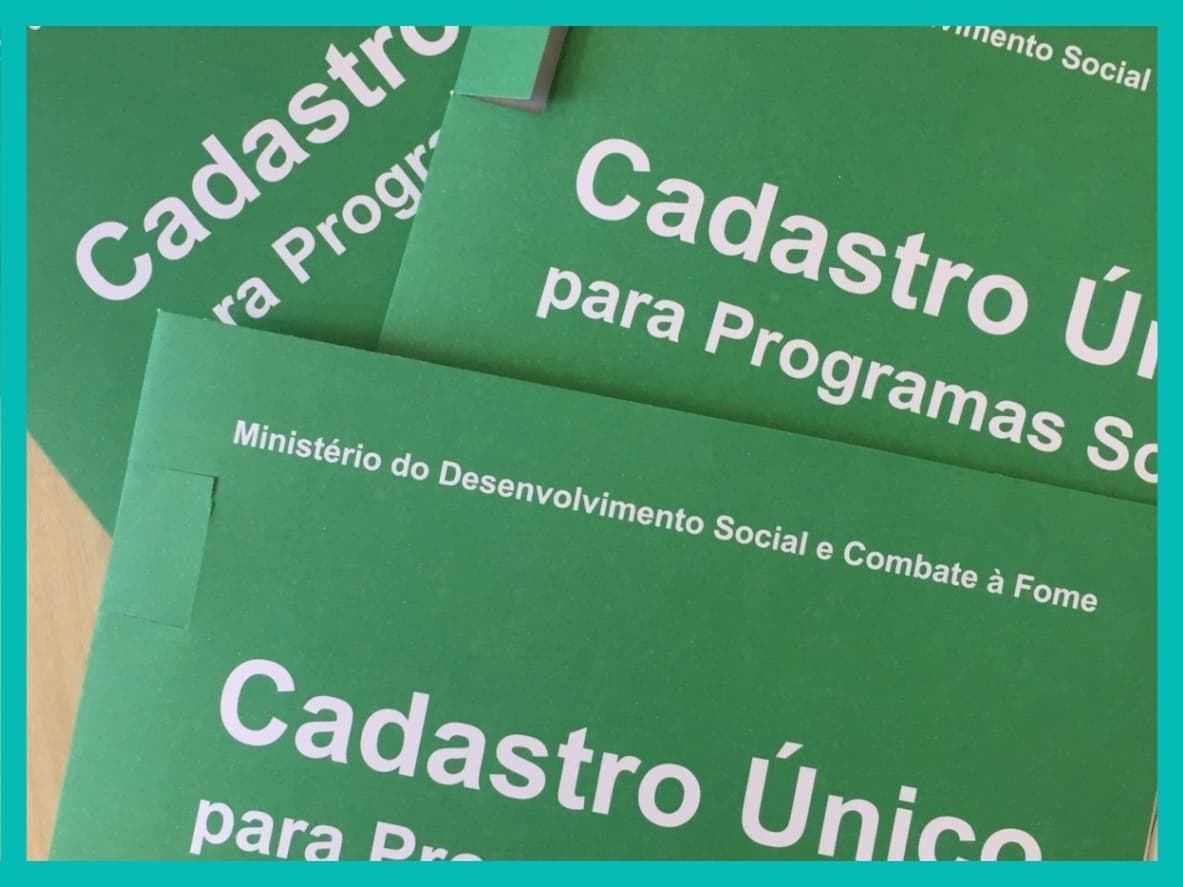 Apostilas do Cadastro Único estão colocadas na mesa.
