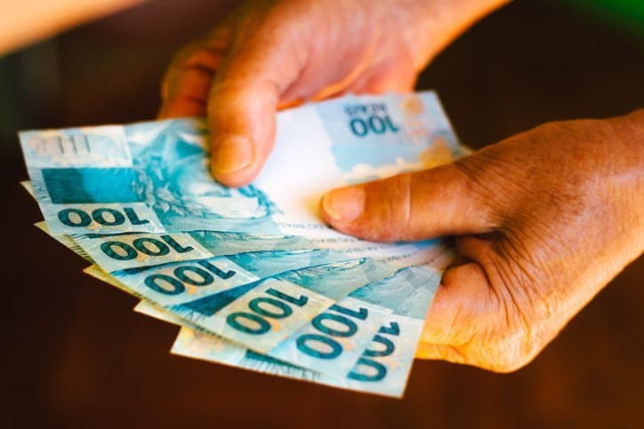 Auxílio Brasil: pessoa contando notas de cem reais