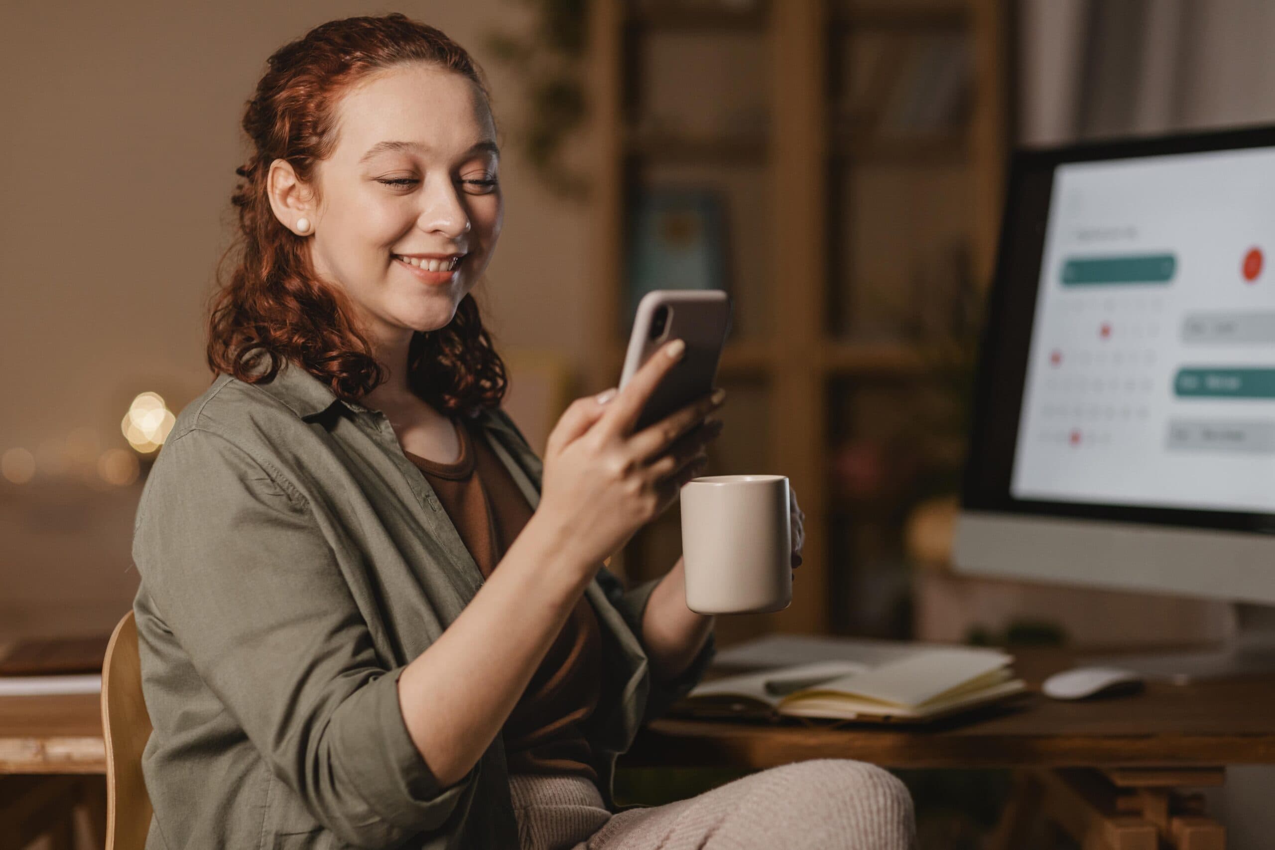 mulher segurando celular e xícara de café (PIX parcelado Santander)