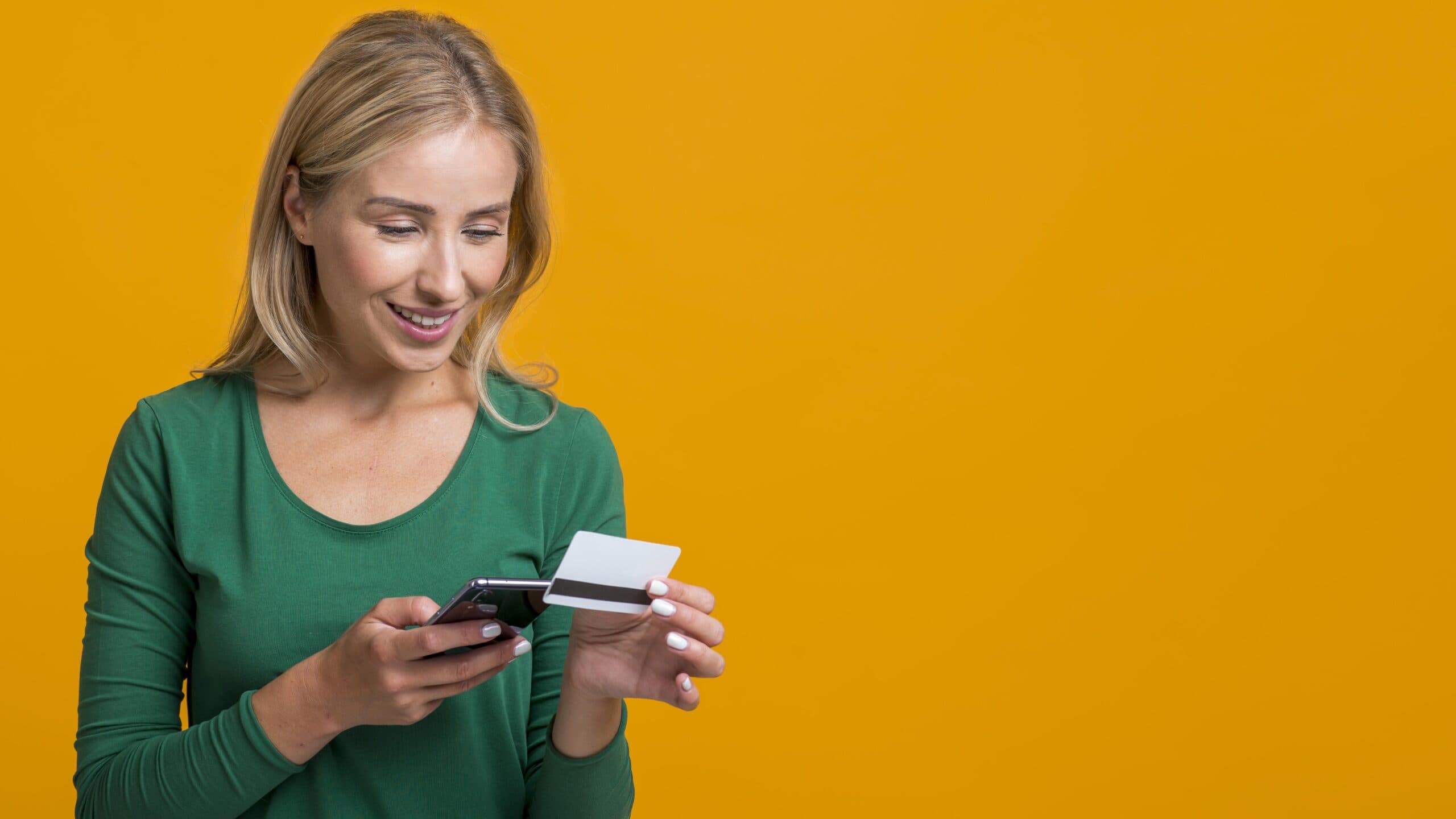 mulher segurando celular e cartão (PIX com cartão de crédito)