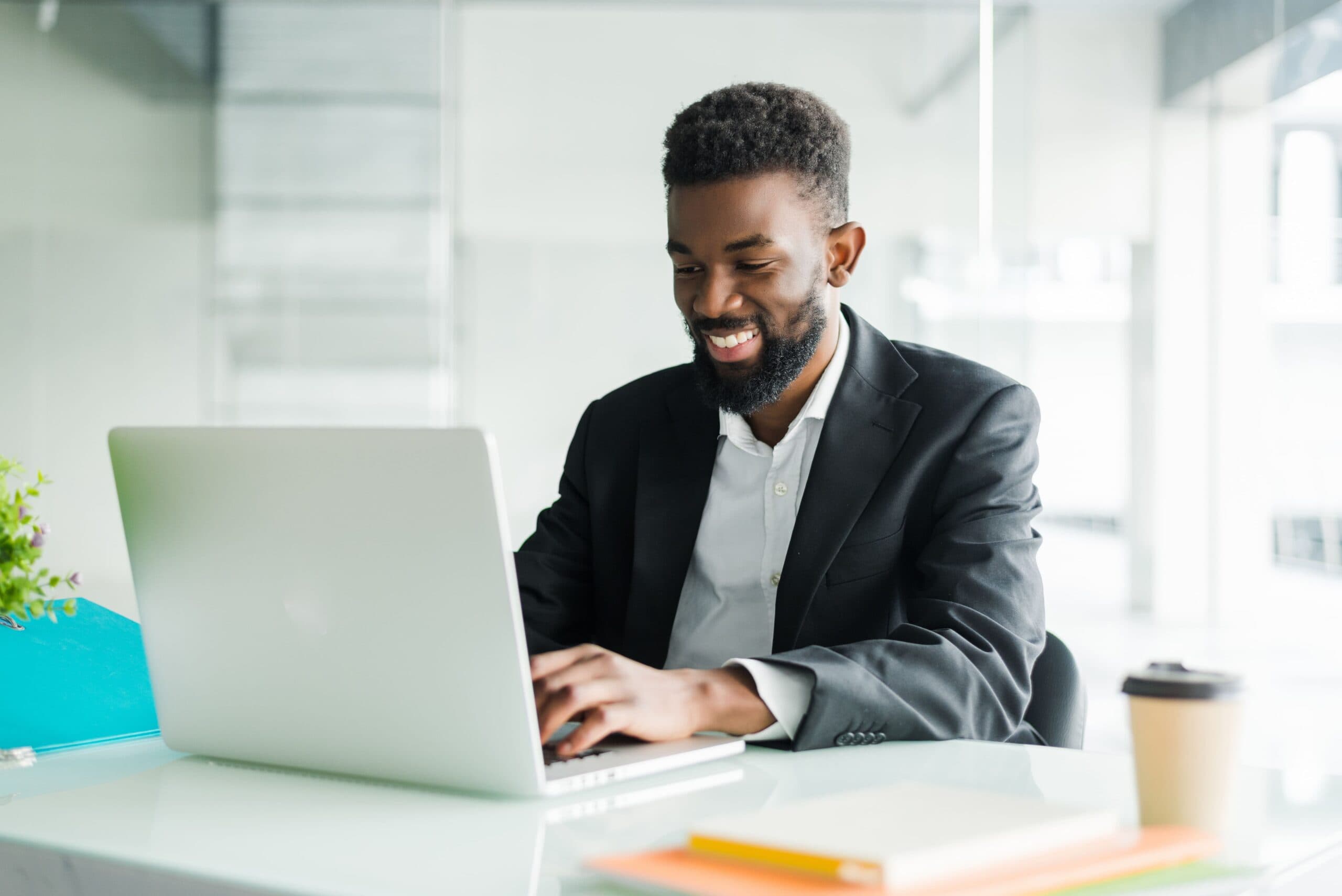 Homem sorrindo na frente de computador (empréstimo para microempresa)