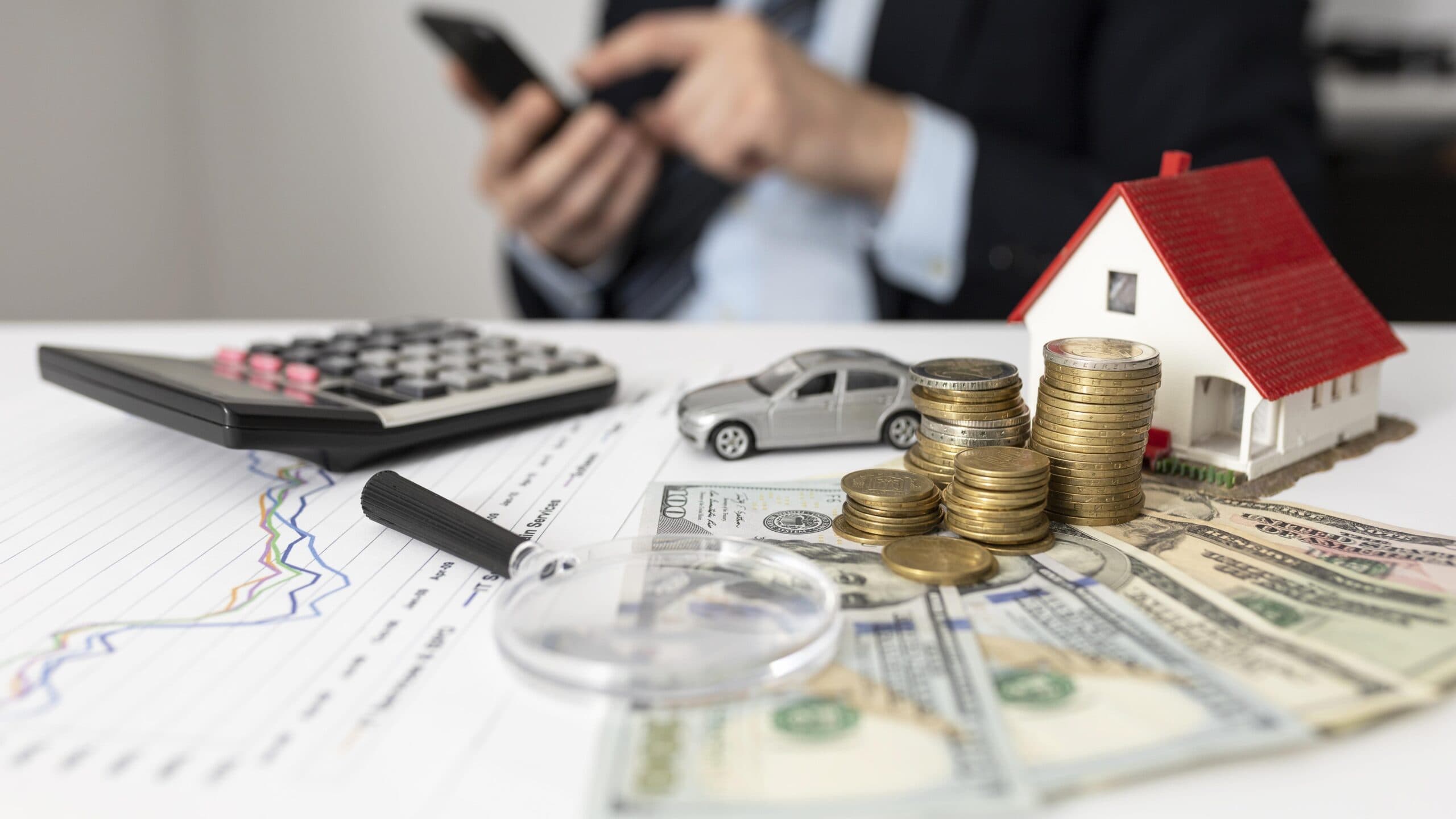 pessoa fazendo cálculos, uma casinha e um carrinho de brinquedo (financiamento para funcionário público)