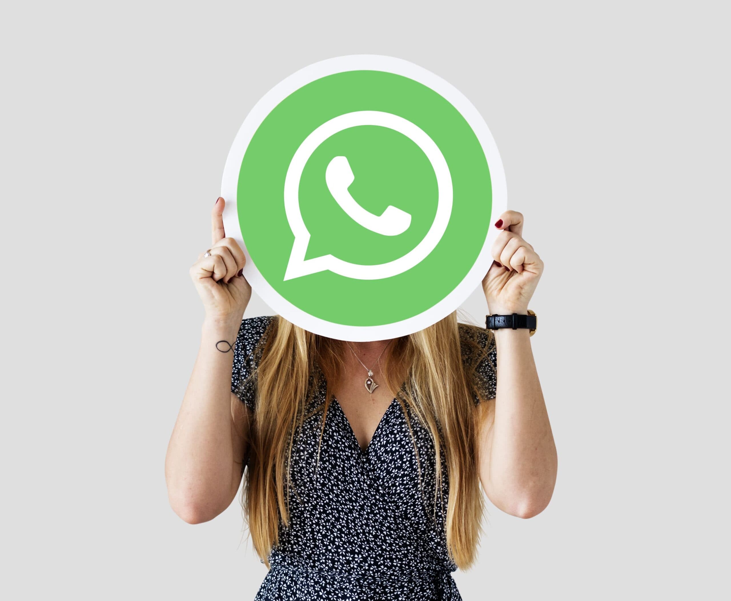 mulher segurando símbolo do WhatsApp (WhatsApp Business)