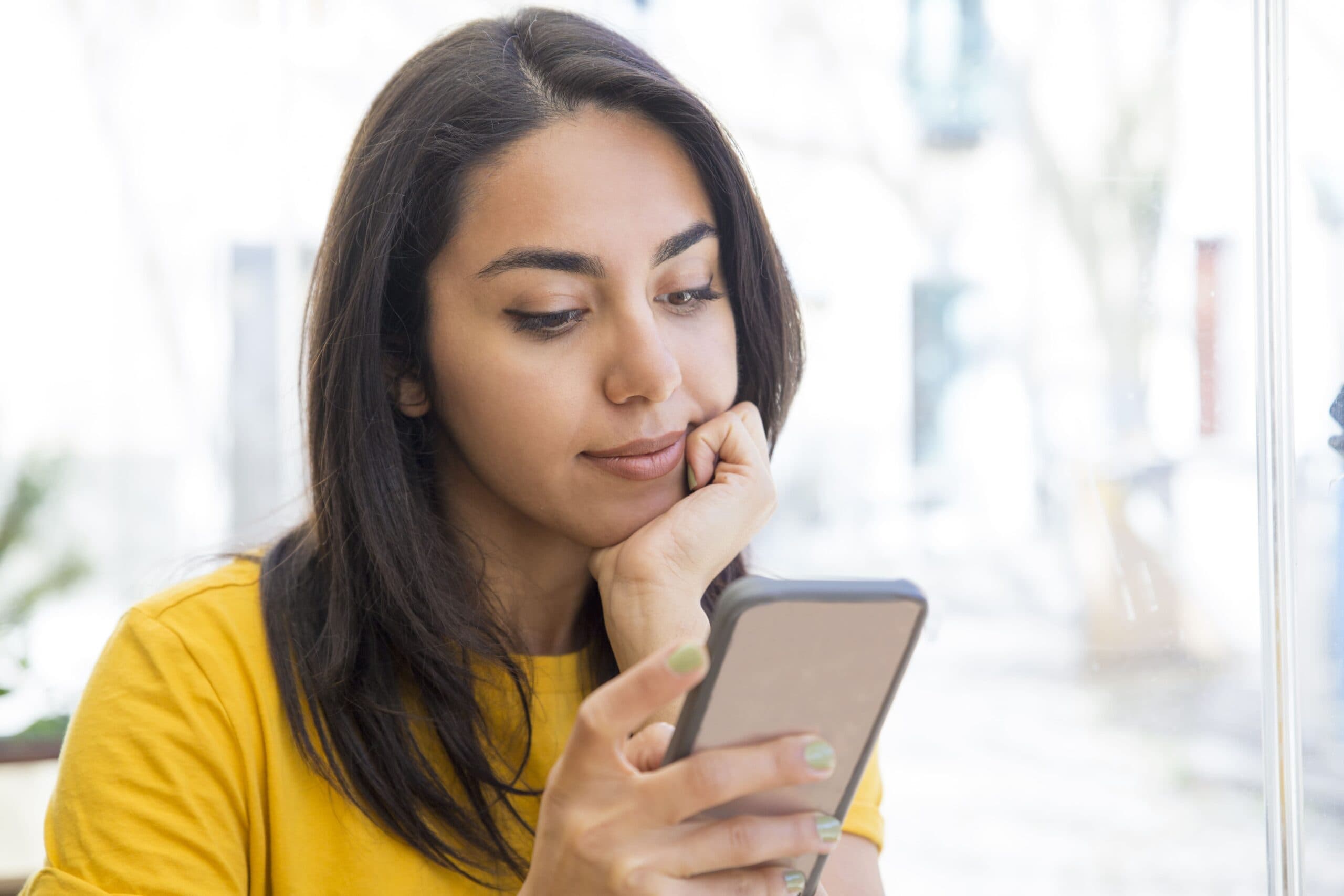 mulher olhando celular (Cartão Cidadão)