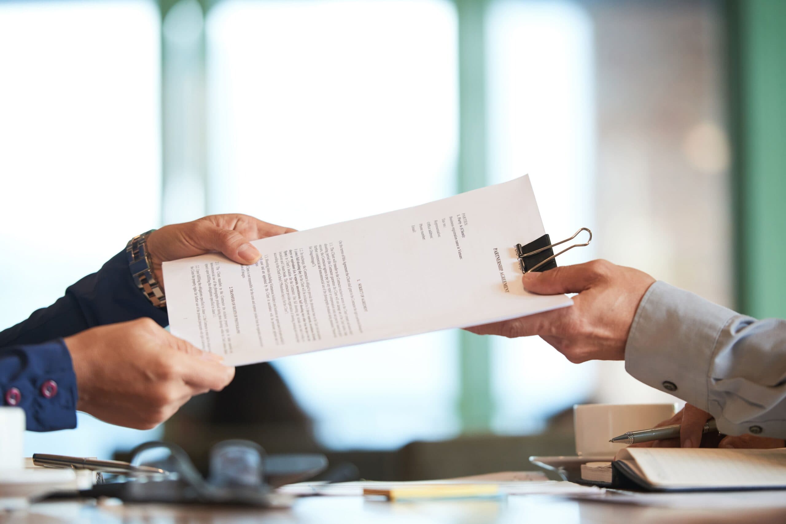 suas pessoas segurando um contrato (transferência de cotas de consórcio)