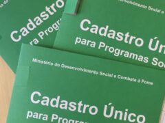 Três apostilas verdes, com a frase Cadastro Único para Programas Sociais na capa.