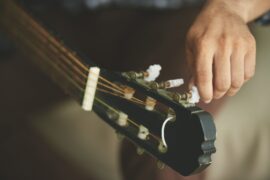 homem afinando guitarra (consórcio de instrumentos musicais)