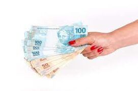Adiantar o salário: uma mulher segura notas de cem e cinquenta reais.