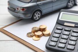veículo em miniatura, ao lado de moedas e calculadora (IPVA 2024)