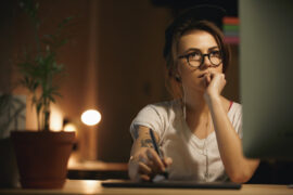 Previdência privada ou consórcio: uma mulher está na frente do computador, pesquisando.