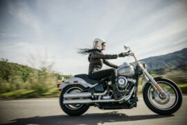 Mulher andando de moto em estrada