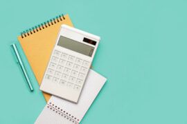 Empréstimo: uma calculadora está em cima de dois blocos de notas. Ao lado há uma caneta.