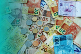 empréstimo com garantia de veículo: diversas notas e moedas de real brasileiros estão espalhadas.