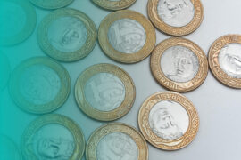 Empréstimo: diversas moedas de um real estão colocadas uma ao lado da outra.