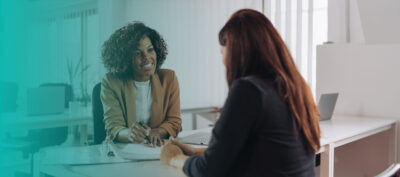 empréstimo: duas mulheres conversando em um cenário corporativo
