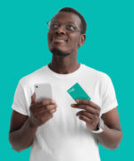 limite do cartão de crédito: homem segurando cartão em uma mão e celular na outra.