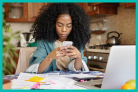 Empréstimo: uma mulher negra está mexendo em um celular.