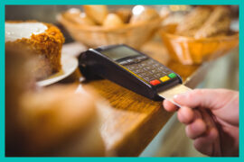 Senha: uma pessoa está na padaria e insere o cartão na maquininha de pagamento.