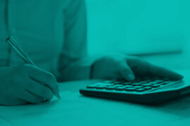Empréstimo consignado: um homem faz anotações em um papel enquanto utiliza a calculadora.