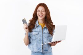 mulher segurando cartão e computador (banco digital para abrir conta)